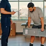 Physical therapist observing a job candidate perform a lift test during post-offer employment screening