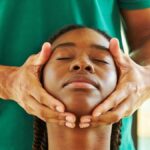 Therapist gently assessing a patient's jaw and facial muscles