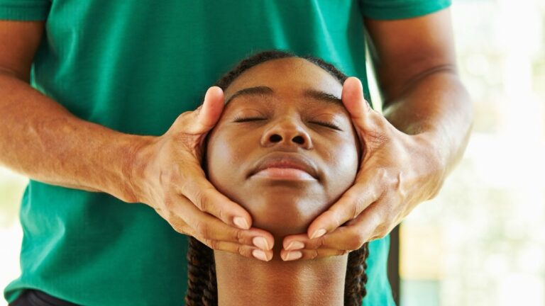 Therapist gently assessing a patient's jaw and facial muscles